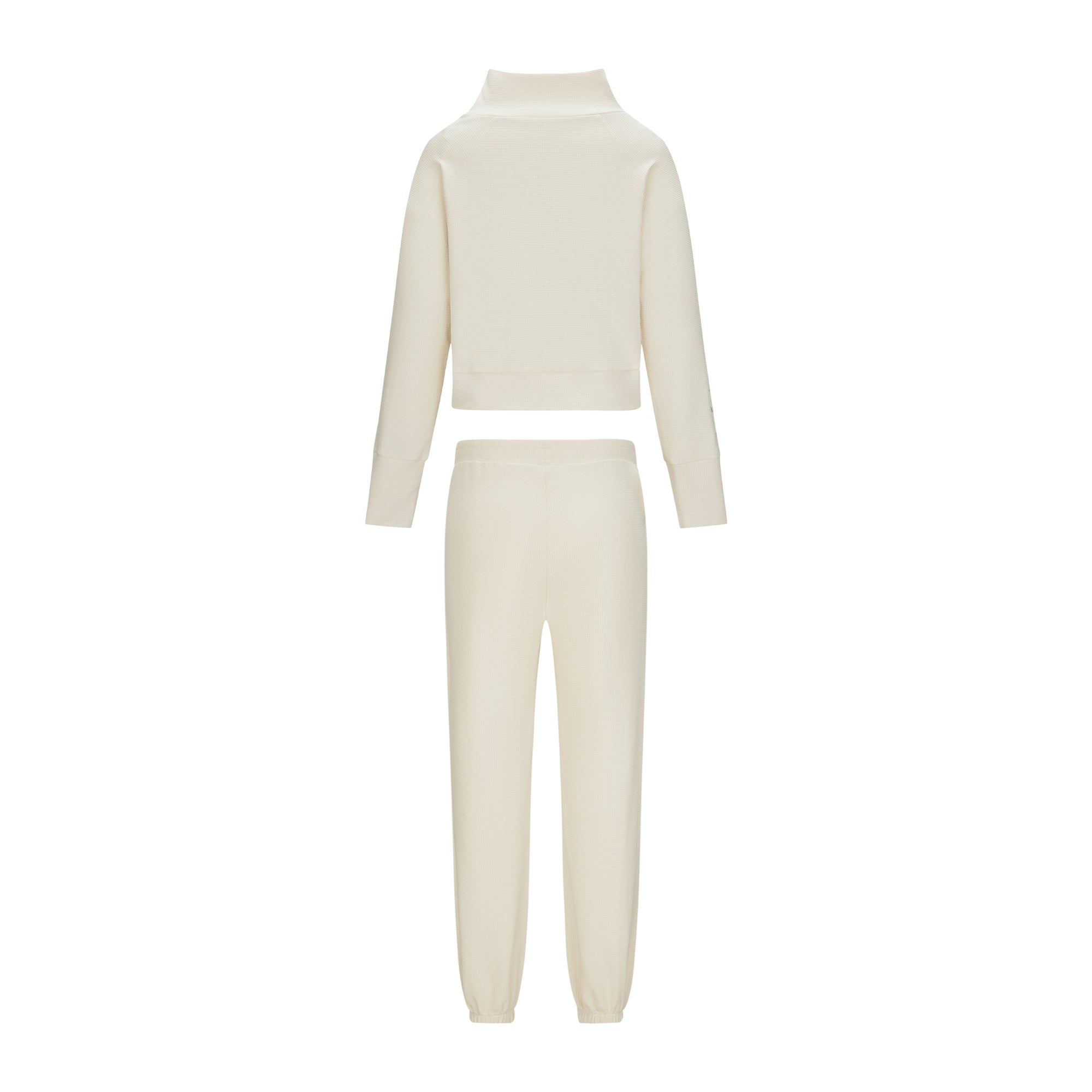 Ensemble yoga/Pilates de la collection GALAYA "SPICA &amp; DENEB", brassière et legging ivoire coordonnés, style minimaliste seconde peau, présenté sur fond clair, lumière douce mettant en valeur la texture et la luminosité du tissu.